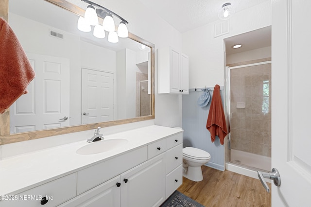 8539 Gate Pkwy W Unit 628, Jacksonville, FL 32216 - bathroom featuring vanity, wood finished floors, visible vents, a stall shower, and toilet