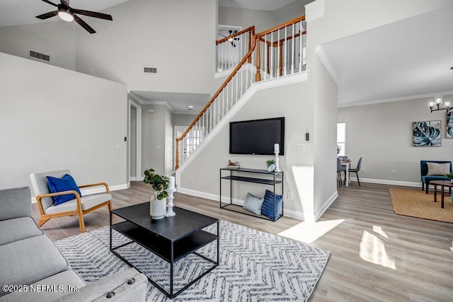 95332 Village Dr, Fernandina Beach, FL 32034 - living room with wood finished floors, baseboards, visible vents, stairs, and ceiling fan with notable chandelier