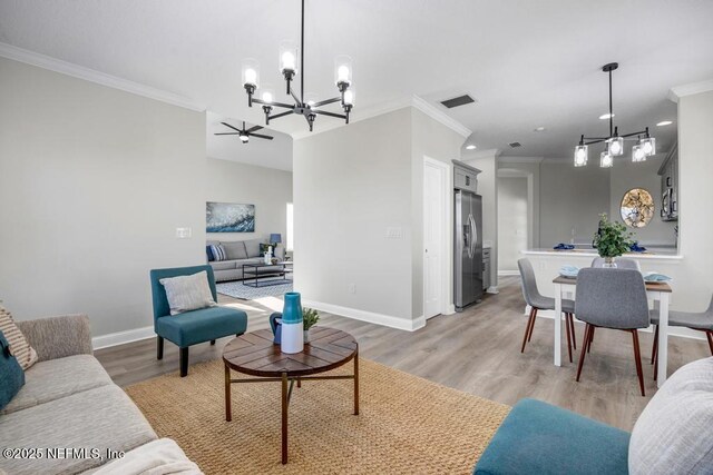 95332 Village Dr, Fernandina Beach, FL 32034 - living area with a chandelier, baseboards, light wood-style floors, and ornamental molding