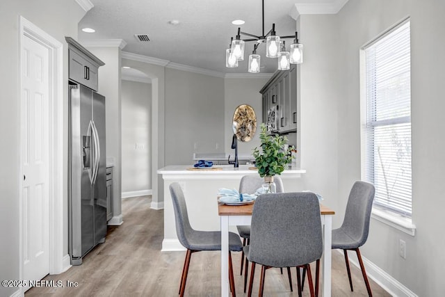 95332 Village Dr, Fernandina Beach, FL 32034 - dining room with visible vents, light wood-style flooring, baseboards, and ornamental molding
