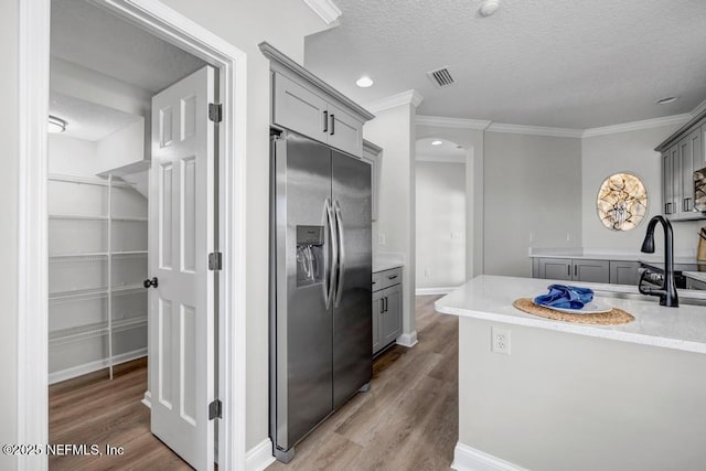 95332 Village Dr, Fernandina Beach, FL 32034 - kitchen featuring gray cabinets, a textured ceiling, and stainless steel refrigerator with ice dispenser