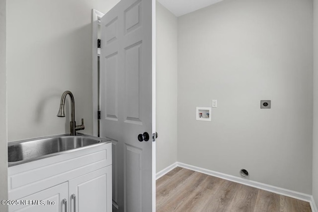 95332 Village Dr, Fernandina Beach, FL 32034 - laundry area with baseboards, cabinet space, a sink, washer hookup, and light wood-style floors