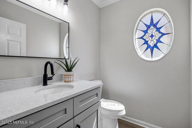 95332 Village Dr, Fernandina Beach, FL 32034 - bathroom with toilet, vanity, baseboards, and wood finished floors