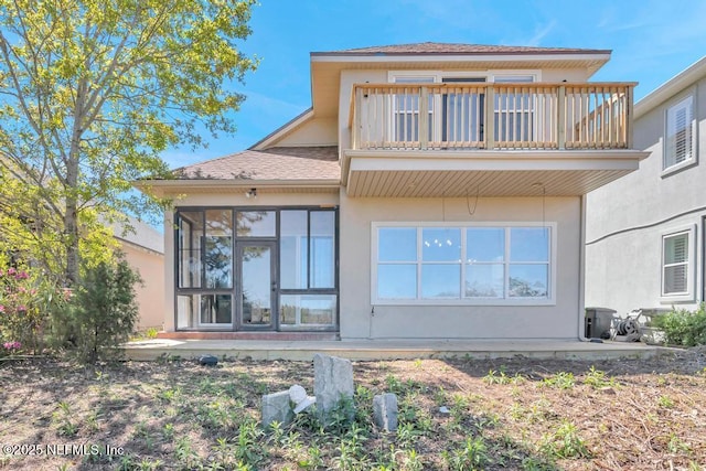 95332 Village Dr, Fernandina Beach, FL 32034 - rear view of house featuring roof with shingles, a balcony, a sunroom, and stucco siding