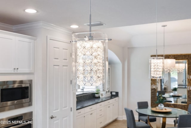 kitchen with crown molding, appliances with stainless steel finishes, dark countertops, white cabinets, and recessed lighting