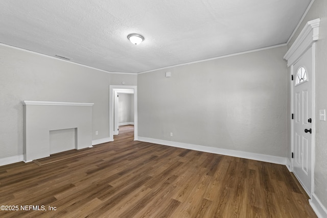 interior space with a textured ceiling, wood finished floors, baseboards, and ornamental molding