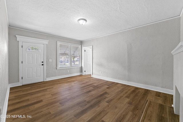 entrance foyer with baseboards, a textured ceiling, wood finished floors, and a textured wall