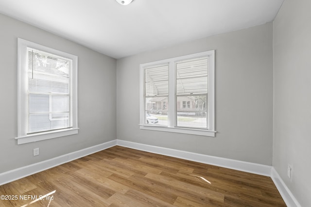empty room featuring baseboards and wood finished floors