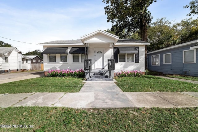 bungalow-style house featuring a front lawn