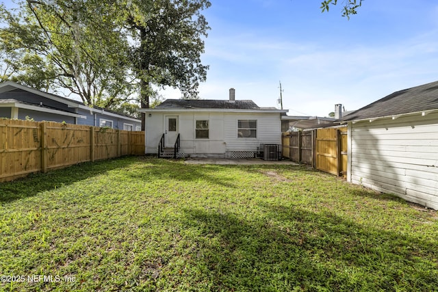 rear view of property featuring a patio, central AC unit, a lawn, and a fenced backyard