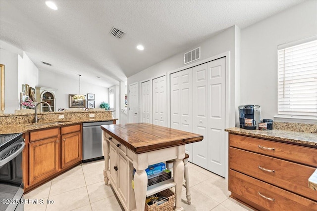 11856 Surfbird Cir Unit 41E, Jacksonville, FL 32256 - kitchen with a sink, brown cabinetry, light tile patterned flooring, and stainless steel dishwasher