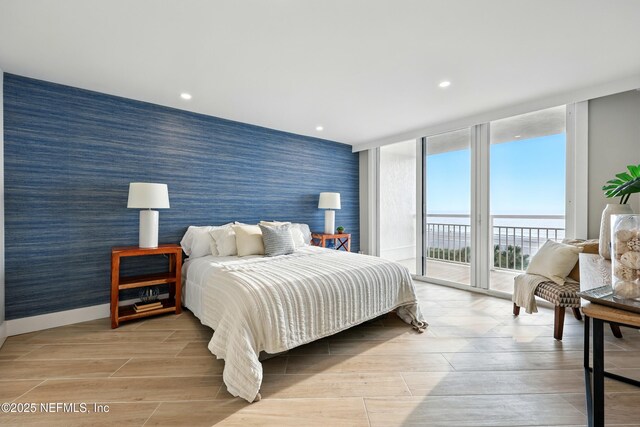 1601 Ocean Dr S Unit 410, Jacksonville Beach, FL 32250 - bedroom featuring wallpapered walls, an accent wall, access to exterior, floor to ceiling windows, and recessed lighting