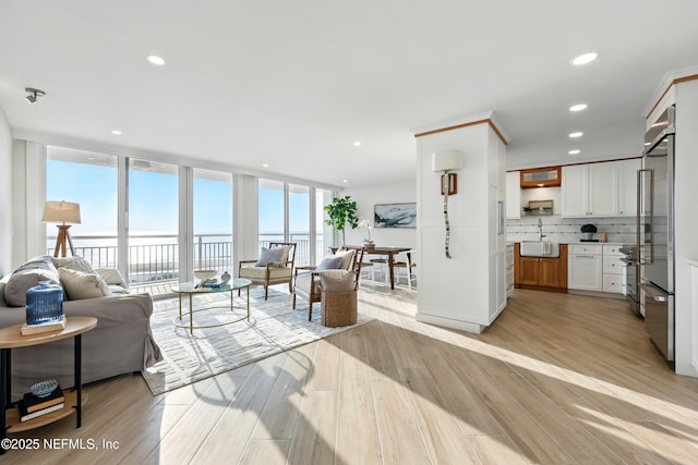 1601 Ocean Dr S Unit 410, Jacksonville Beach, FL 32250 - living room featuring expansive windows, light wood-type flooring, recessed lighting, and a water view