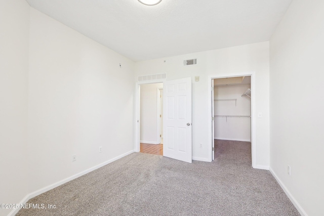 10435 Midtown Pkwy Unit 448, Jacksonville, FL 32246 - unfurnished bedroom with baseboards, a spacious closet, visible vents, and carpet floors