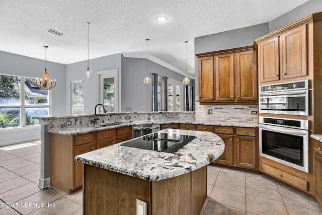 1317 Honeysuckle Dr, Saint Johns, FL 32259 - kitchen with visible vents, a sink, appliances with stainless steel finishes, a peninsula, and brown cabinets