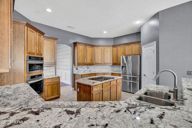 1317 Honeysuckle Dr, Saint Johns, FL 32259 - kitchen with light stone counters, a sink, black electric cooktop, and stainless steel refrigerator with ice dispenser