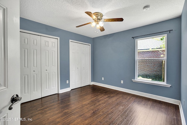 1317 Honeysuckle Dr, Saint Johns, FL 32259 - unfurnished bedroom with a textured ceiling, dark wood-style flooring, baseboards, and multiple closets