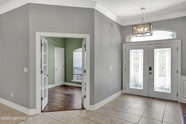 1317 Honeysuckle Dr, Saint Johns, FL 32259 - entryway featuring crown molding, light tile patterned floors, a textured ceiling, french doors, and a notable chandelier