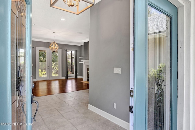 1317 Honeysuckle Dr, Saint Johns, FL 32259 - foyer featuring ornamental molding, light tile patterned floors, baseboards, and an inviting chandelier