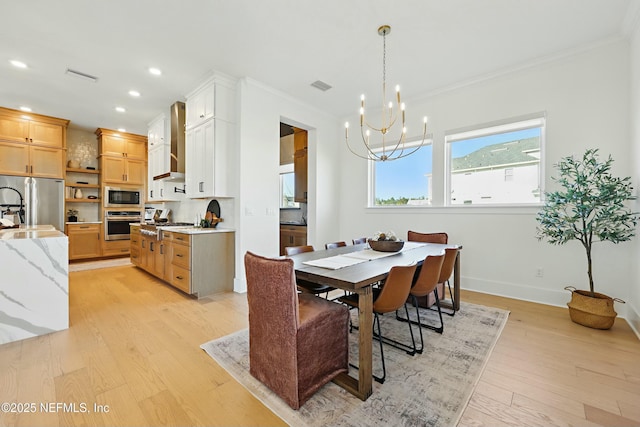 dining room with ornamental molding, recessed lighting, light wood-style floors, an inviting chandelier, and baseboards