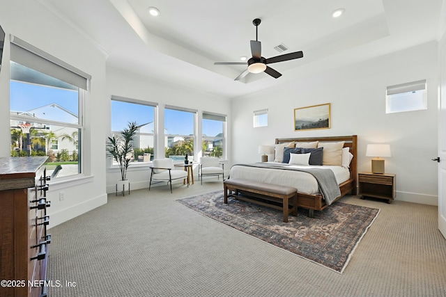 bedroom with a tray ceiling, baseboards, and light colored carpet