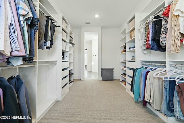 walk in closet with visible vents and carpet