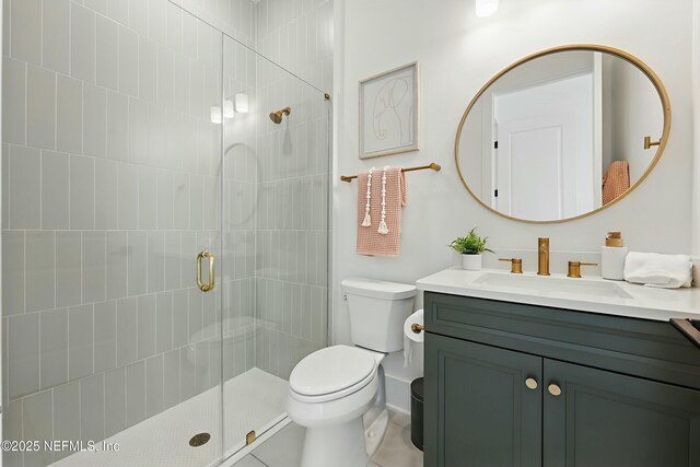 full bath with vanity, tile patterned floors, toilet, and a stall shower