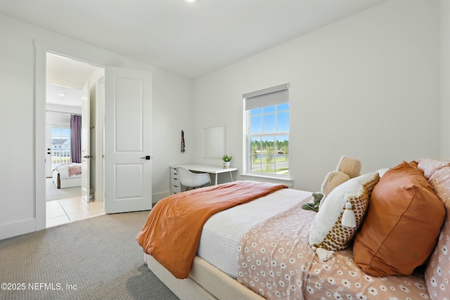 bedroom with light tile patterned floors, light colored carpet, and baseboards