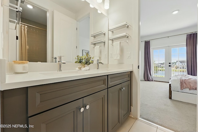 full bath featuring a sink, ensuite bathroom, double vanity, and tile patterned flooring