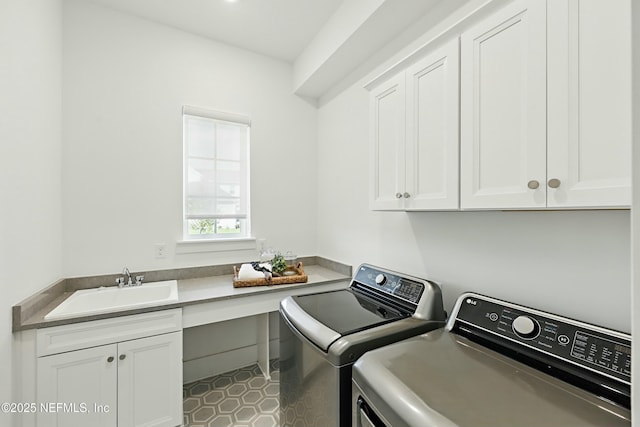 clothes washing area featuring cabinet space, washer and dryer, and a sink