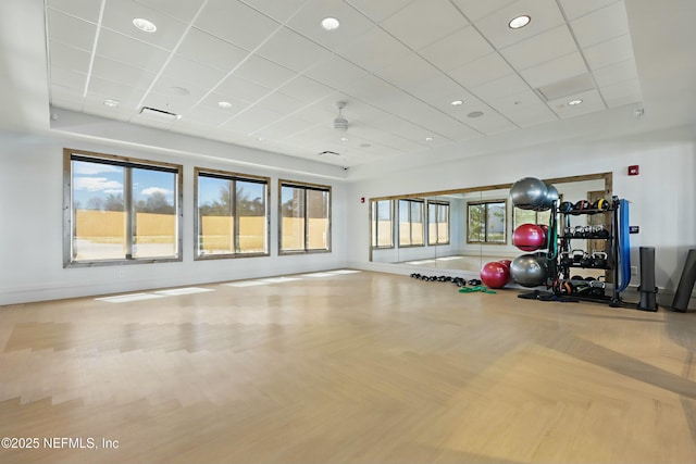 exercise area featuring visible vents, a healthy amount of sunlight, and baseboards