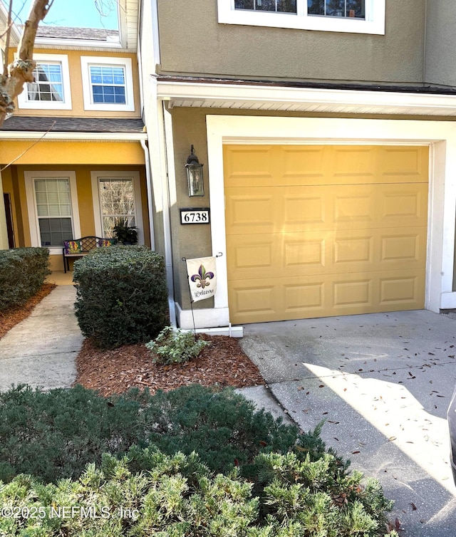 6738 White Blossom Cir Unit 36G, Jacksonville, FL 32258 - property entrance with driveway, stucco siding, and an attached garage