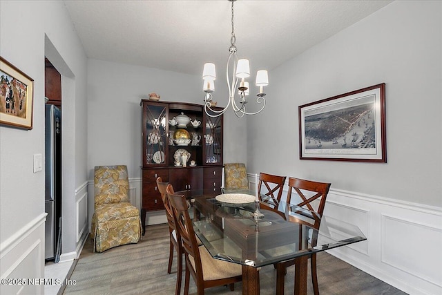 6738 White Blossom Cir Unit 36G, Jacksonville, FL 32258 - dining area with a decorative wall, wainscoting, a notable chandelier, and wood finished floors