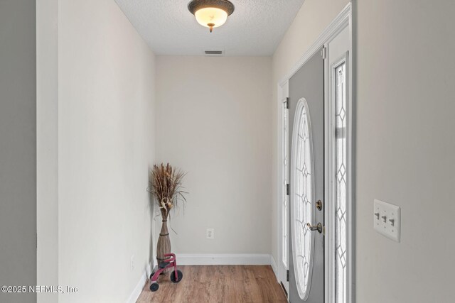 5398 Laurie Ln, Middleburg, FL 32068 - entryway with a textured ceiling, wood finished floors, and baseboards