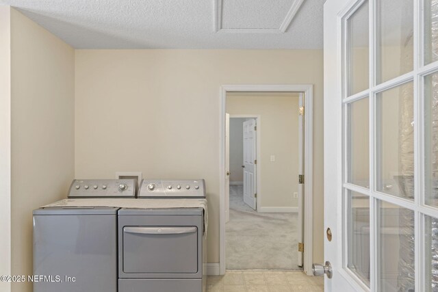5398 Laurie Ln, Middleburg, FL 32068 - clothes washing area featuring washing machine and dryer, a textured ceiling, light colored carpet, and baseboards