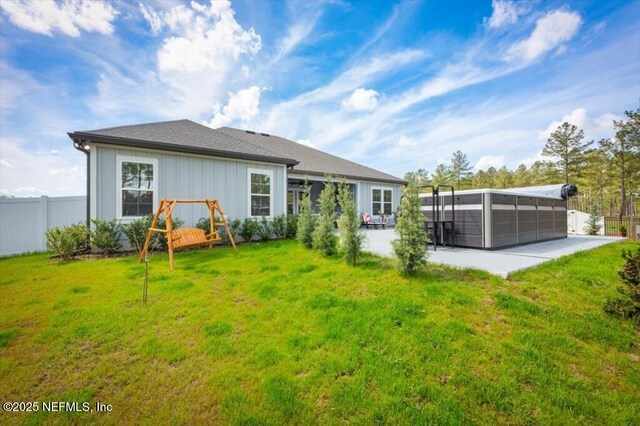 rear view of property with a patio area, a yard, and fence