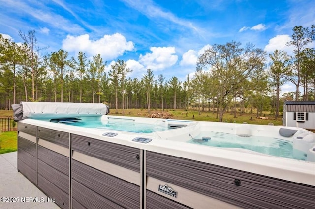 view of pool featuring an outbuilding and a hot tub