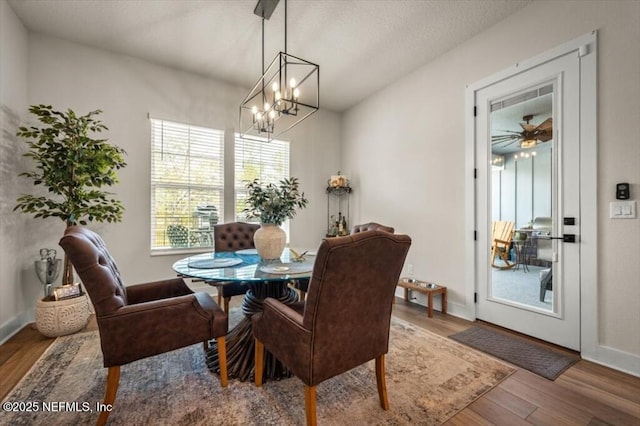 dining room with a chandelier, baseboards, and wood finished floors