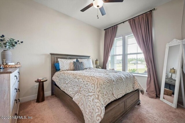 bedroom with light colored carpet, baseboards, and ceiling fan