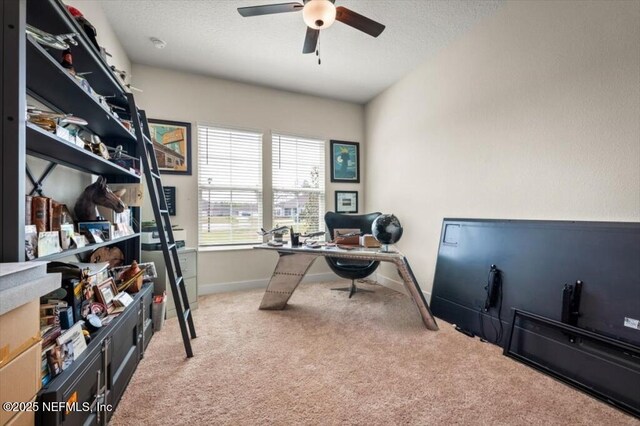 carpeted home office with baseboards, a textured ceiling, and a ceiling fan