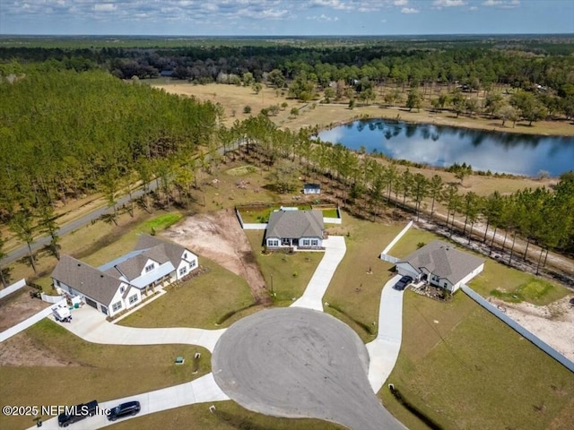 drone / aerial view with a forest view and a water view