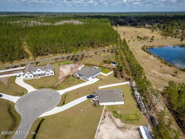 aerial view featuring a wooded view and a water view