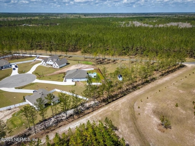 bird's eye view with a wooded view