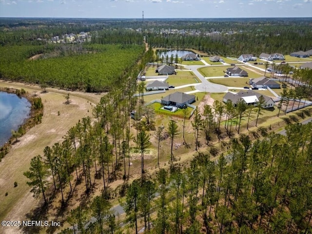 birds eye view of property with a view of trees and a water view