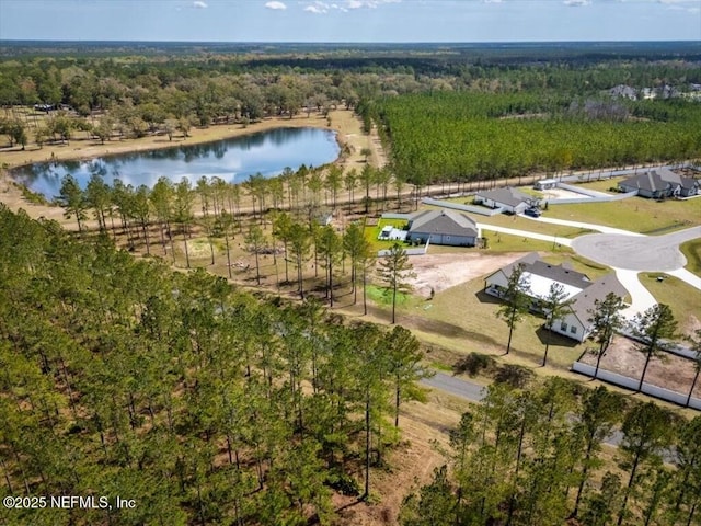 drone / aerial view featuring a wooded view and a water view
