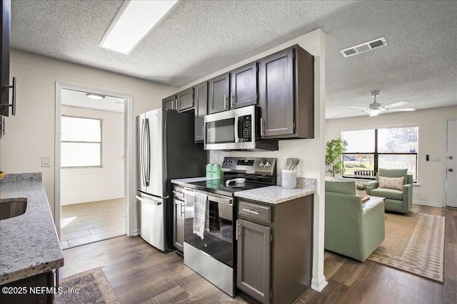 14319 Cedar Island Rd N, Jacksonville, FL 32250 - kitchen featuring dark wood-style flooring, a textured ceiling, visible vents, a ceiling fan, and appliances with stainless steel finishes