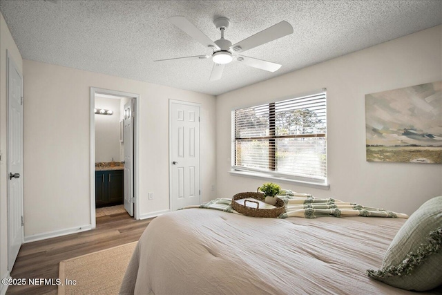 14319 Cedar Island Rd N, Jacksonville, FL 32250 - bedroom featuring wood finished floors, a textured ceiling, ensuite bath, baseboards, and ceiling fan