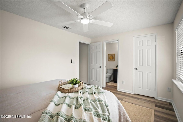 14319 Cedar Island Rd N, Jacksonville, FL 32250 - bedroom with baseboards, a textured ceiling, ensuite bath, visible vents, and wood finished floors