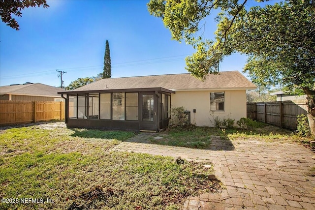 14319 Cedar Island Rd N, Jacksonville, FL 32250 - rear view of property featuring a fenced backyard, a sunroom, stucco siding, and a yard
