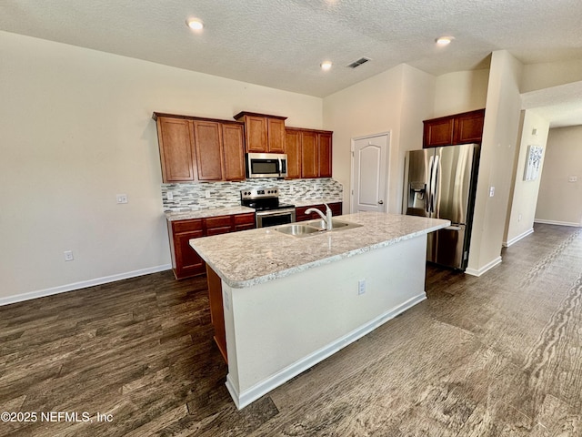 kitchen featuring visible vents, backsplash, vaulted ceiling, stainless steel appliances, and a sink
